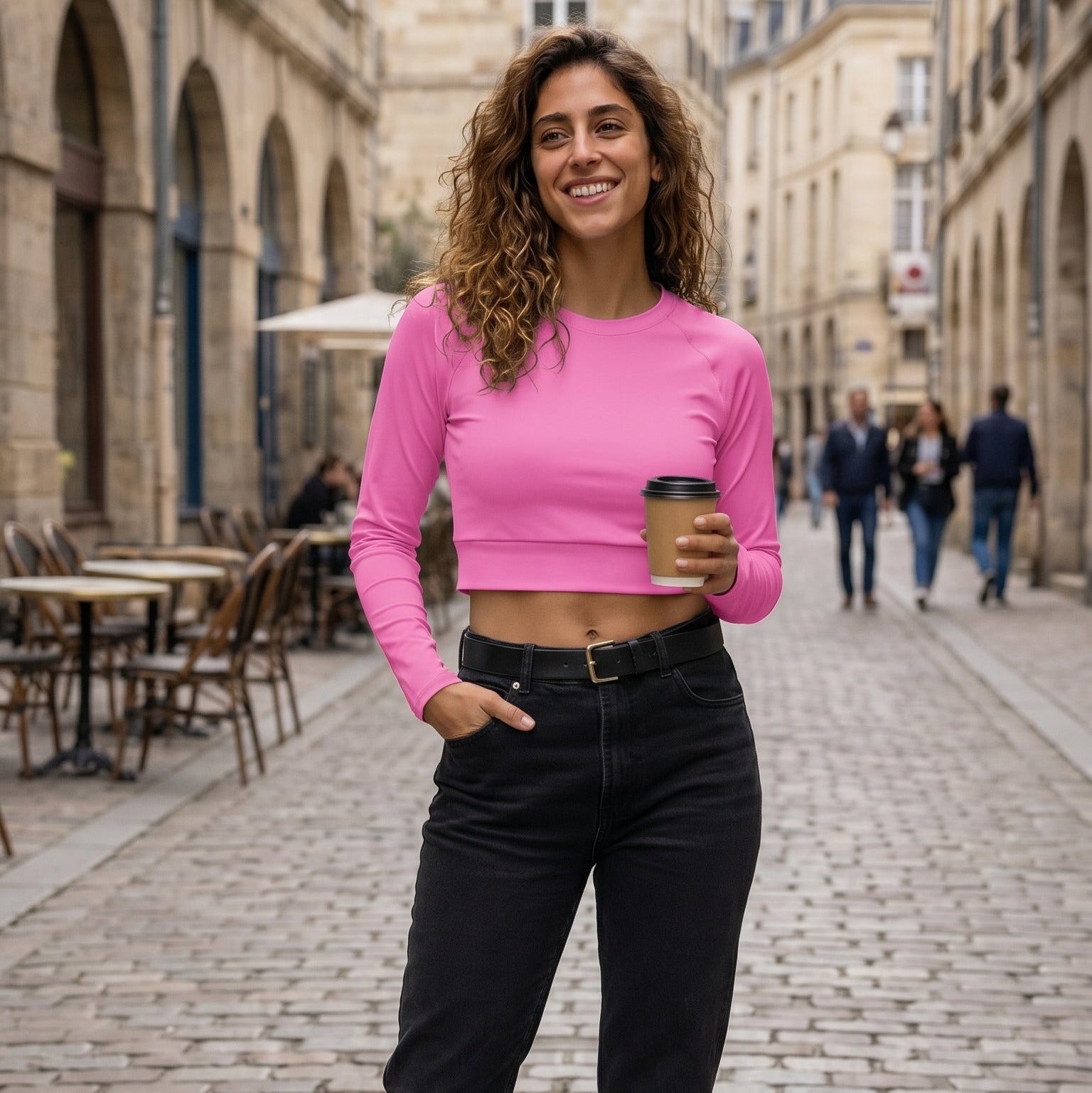 AMMOR PARIS recycled long‑sleeve crop top in bold pink, displayed flat on a deep black background to highlight its UPF50+ recycled performance fabric, sculpted cropped silhouette, raglan sleeves and wide double‑layered waistband, expressing the brand’s elevated Paris‑born sustainable athletic aesthetic.
