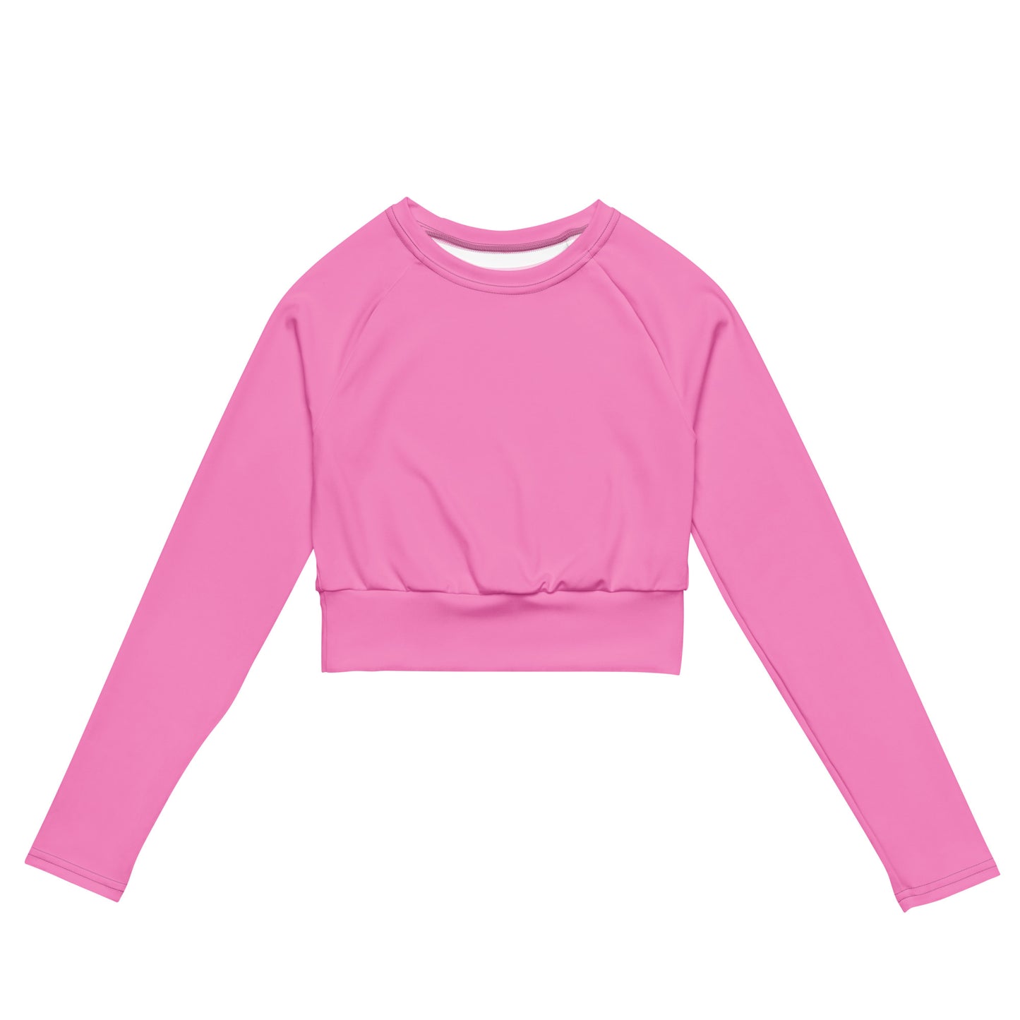 AMMOR PARIS recycled long‑sleeve crop top in bold pink, photographed flat against a deep black background to emphasize its UPF50+ recycled performance fabric, sculpted cropped silhouette, raglan sleeves and wide double‑layered waistband, showcasing the brand’s refined Paris‑born sustainable athletic design.
