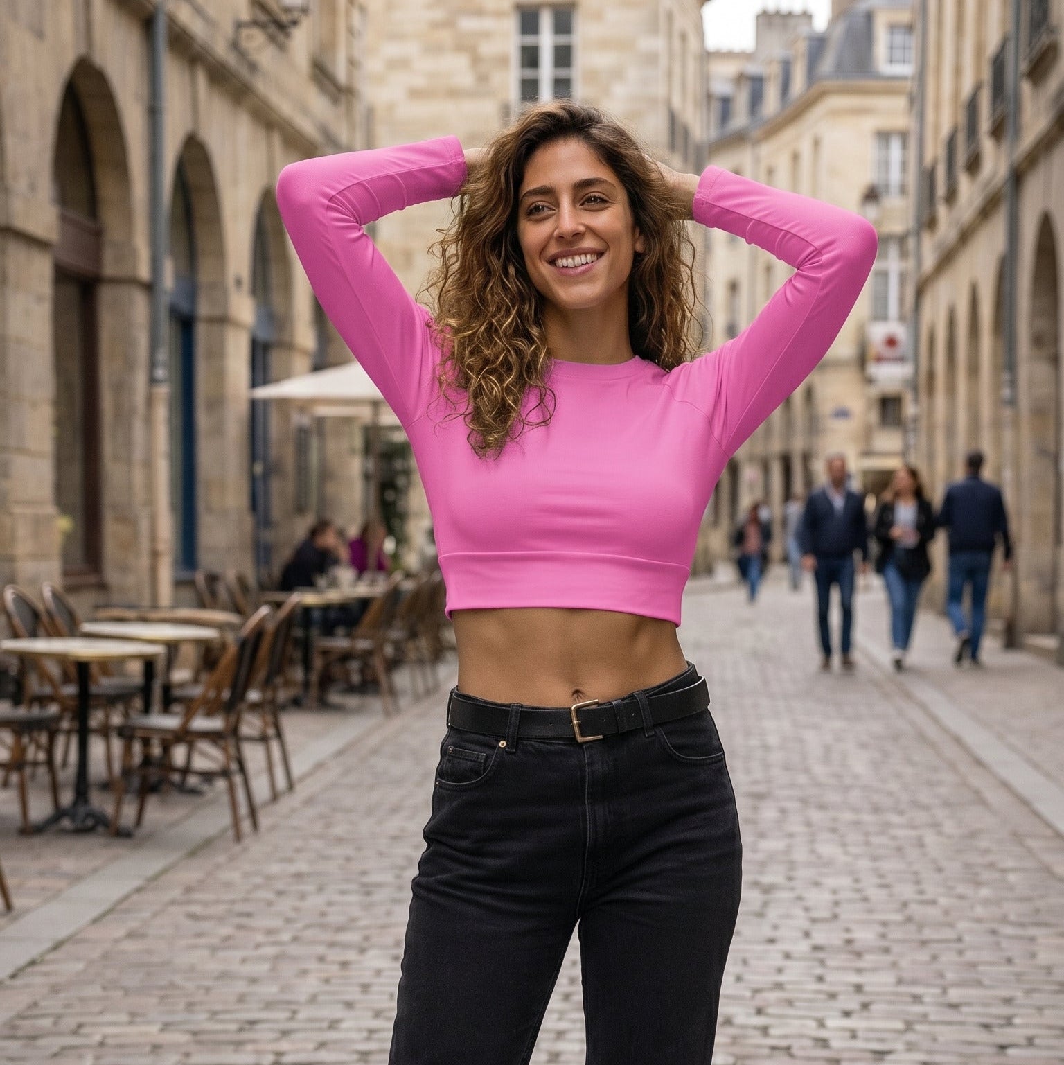 AMMOR PARIS recycled long‑sleeve crop top in vibrant pink, displayed flat on a deep black background to highlight its UPF50+ recycled performance fabric, sculpted cropped silhouette, raglan sleeves and wide double‑layered waistband, reflecting the brand’s refined Paris‑born sustainable athletic aesthetic.
