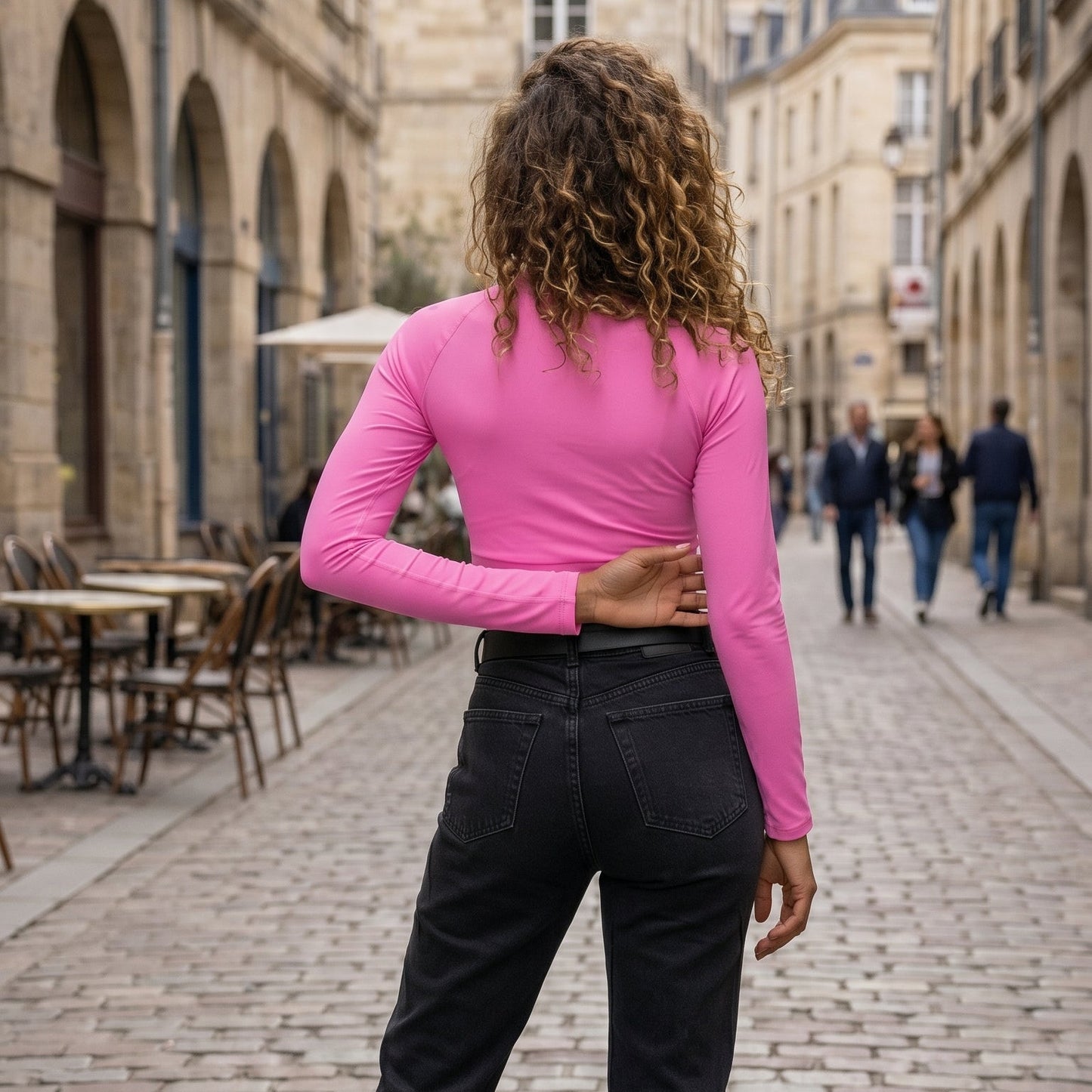 AMMOR PARIS recycled long‑sleeve crop top in vibrant pink, laid flat on a black background to emphasize its sculpted cropped fit, UPF50+ recycled performance fabric, raglan sleeves and wide double‑layered waistband, showcasing the brand’s modern Paris‑born sustainable athletic aesthetic.