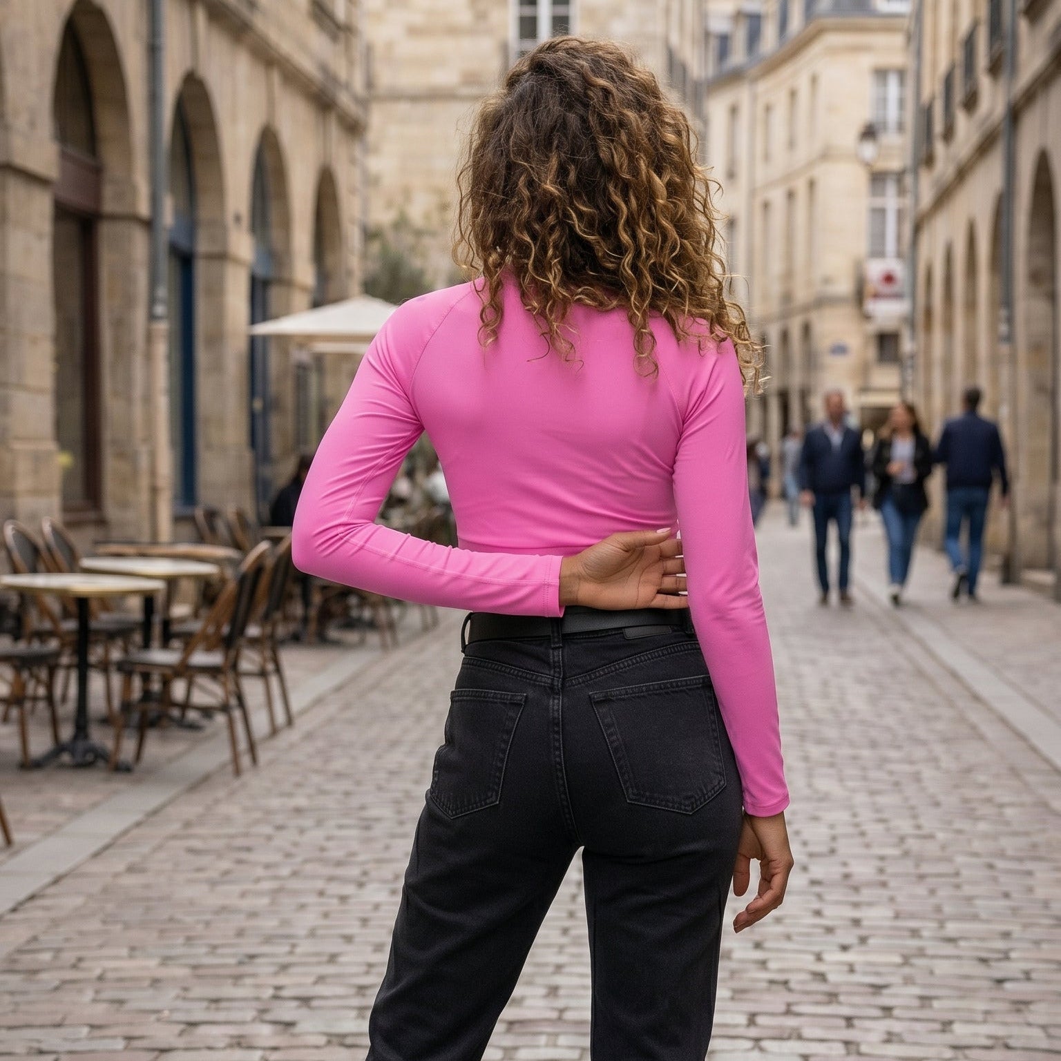 AMMOR PARIS recycled long‑sleeve crop top in vibrant pink, laid flat on a black background to emphasize its sculpted cropped fit, UPF50+ recycled performance fabric, raglan sleeves and wide double‑layered waistband, showcasing the brand’s modern Paris‑born sustainable athletic aesthetic.