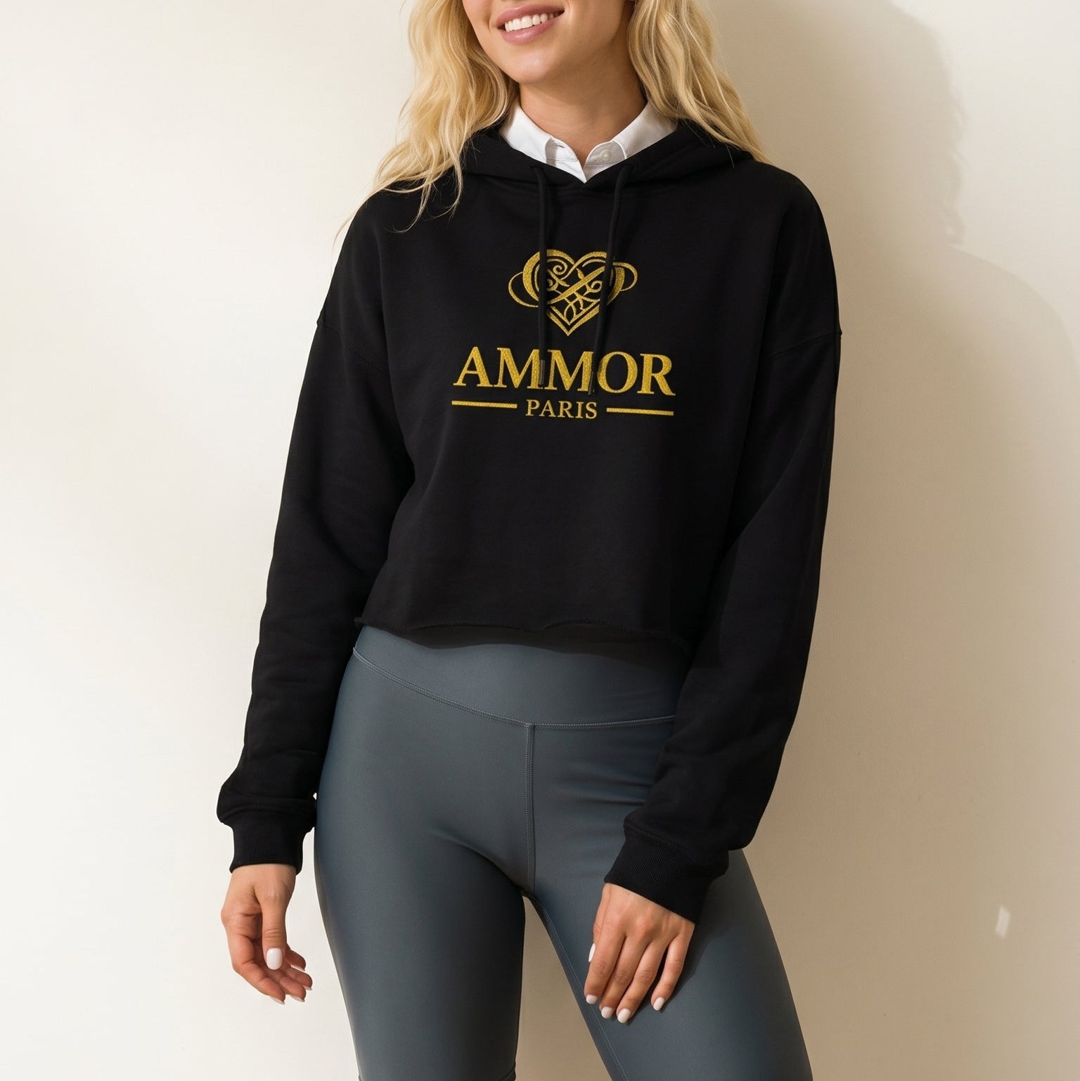 AMMOR PARIS women’s black cropped hoodie with gold luxury designer logo, premium high‑end streetwear fashion hoodie modeled for urban apparel, modern minimalist luxury clothing brand piece
