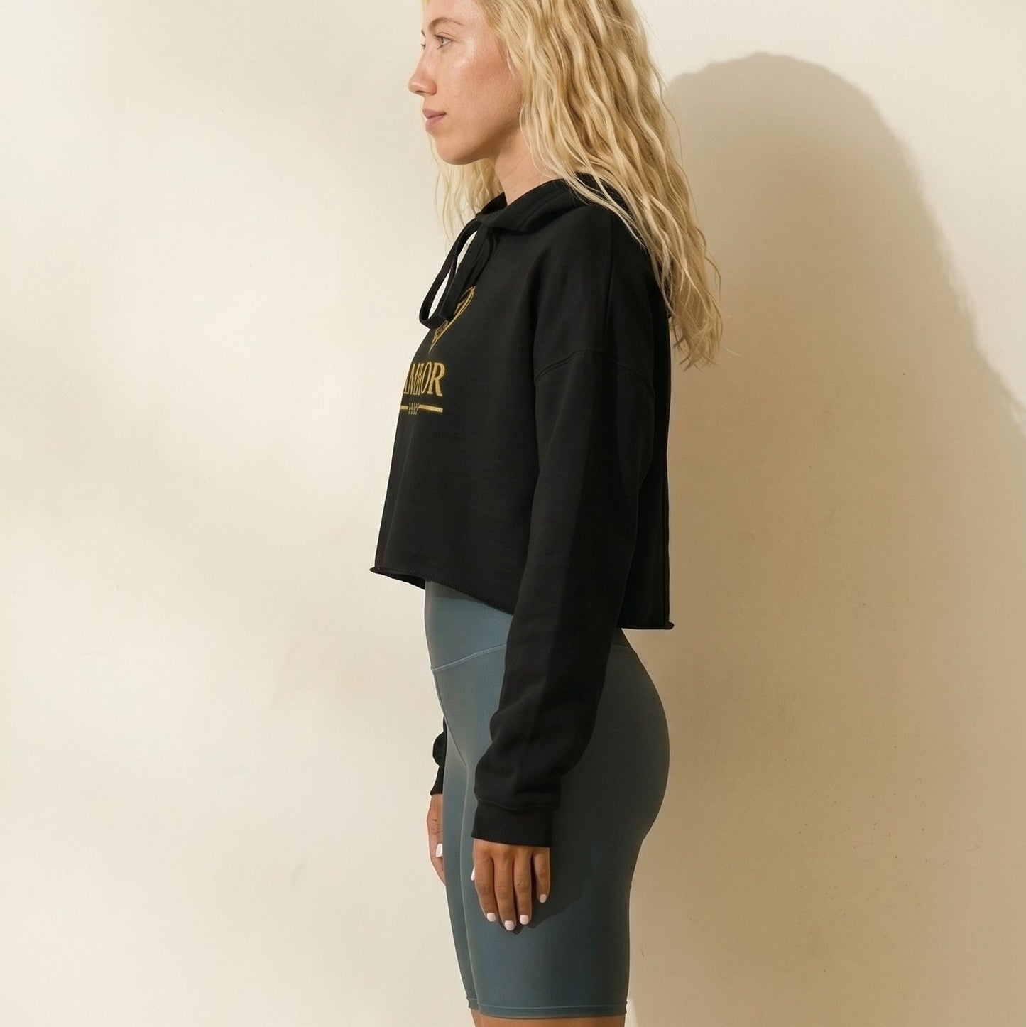 AMMOR PARIS women’s black cropped hoodie with gold luxury designer logo, premium high‑end streetwear fashion hoodie modeled for urban lifestyle and modern minimalist apparel, contemporary Paris‑inspired luxury clothing brand piece for elevated designer wardrobe