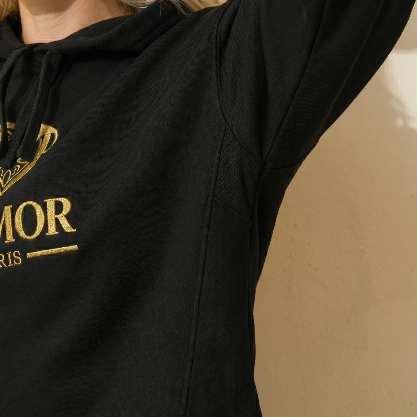 Black AMMOR PARIS cropped hoodie with gold logo worn by a model, premium streetwear fashion apparel for women.