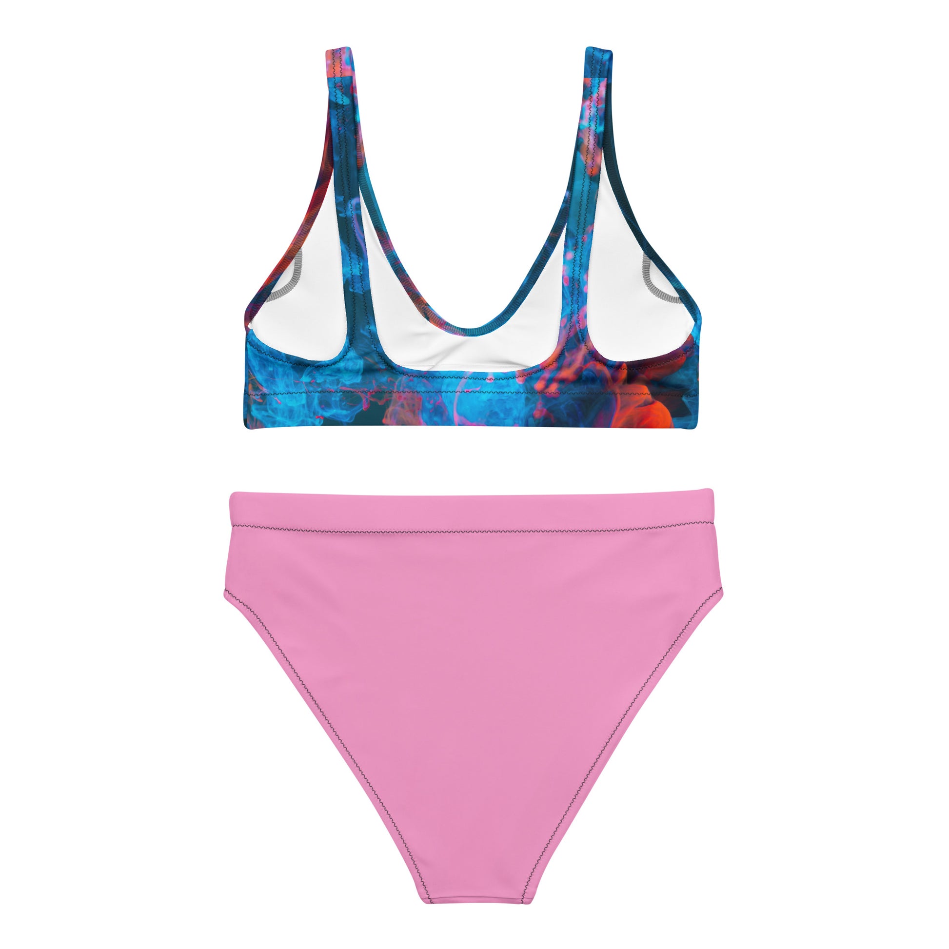 Female model posing in a red‑blue patterned bikini top with high‑waisted pink bottoms, AMMOR PARIS recycled bikini set displayed in a clean studio for luxury sustainable swimwear, modern designer summer fashion and elevated beachwear aesthetics.