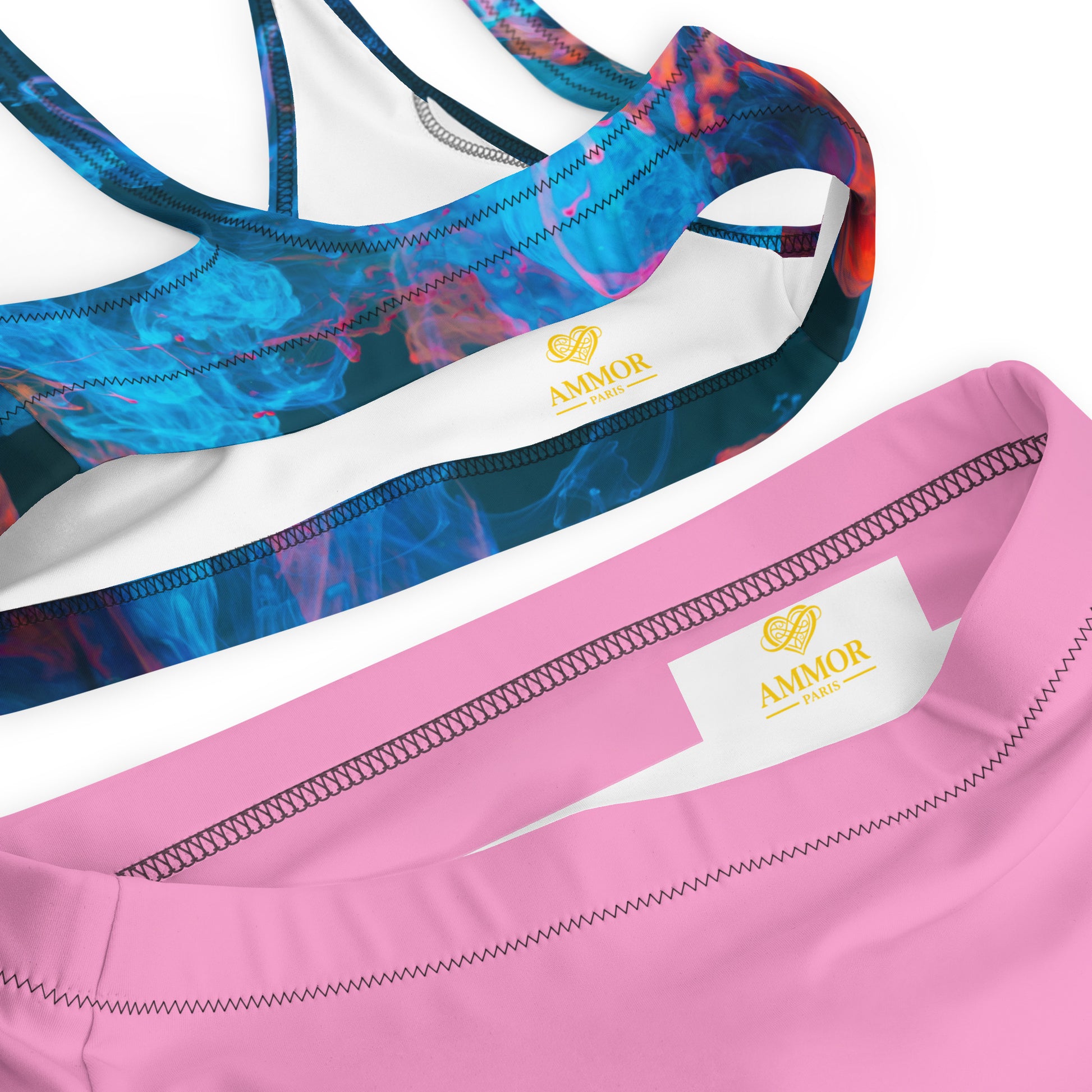 Female model wearing a red‑blue patterned bikini top with high‑waisted pink bottoms, AMMOR PARIS recycled bikini set showcased in a clean studio to highlight the brand’s luxury aesthetic, modern designer swimwear identity and elevated sustainable fashion vision.